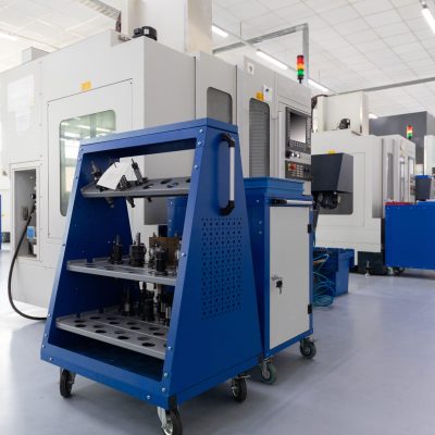 Row of equipment producing metal parts in works. Photo with depth of field